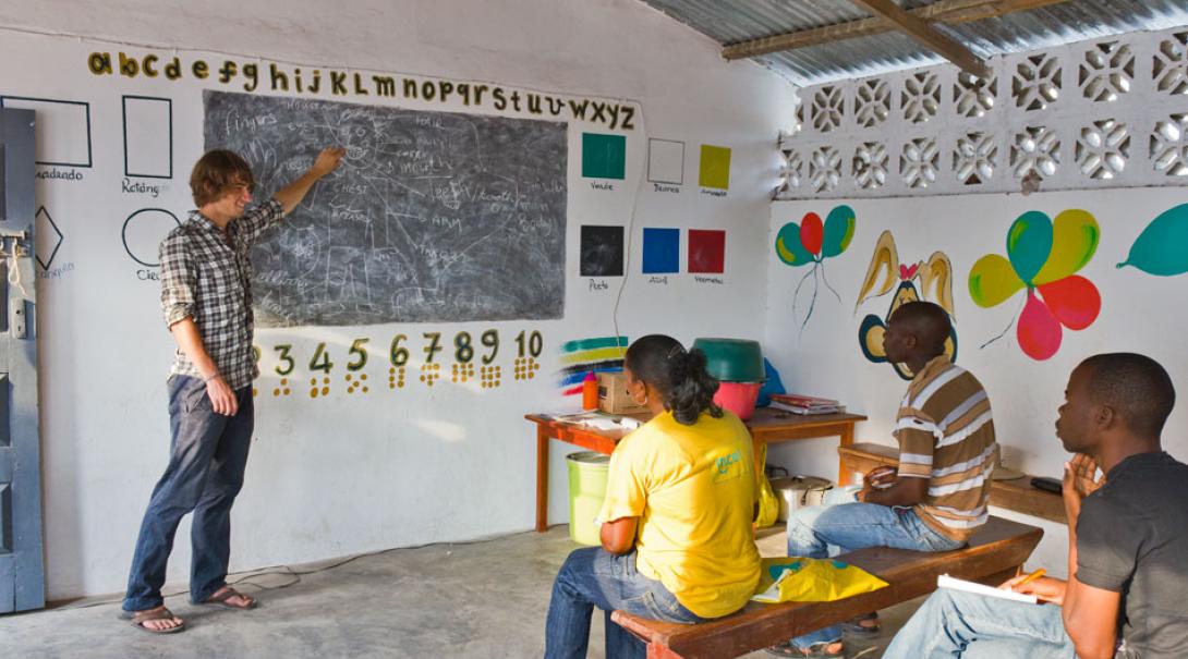 Tras reconstruir una escuela, un maestro voluntario ayuda a la comunidad local. Voluntario de ayuda humanitaria en Mozambique enseñando a la comunidad local.